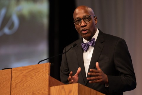 A photo of J. Herbert Nelson speaking at a podium.